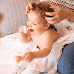 Mãe fazendo carinho no bebê enrolado em toalha após o banho, Kit Mamãe & Bebê